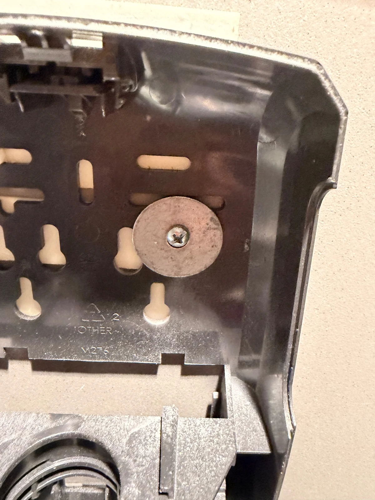 A screw and washer visible inside an open soap-dispenser housing.